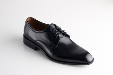 brown man's leather shoe with shoelaces on white background