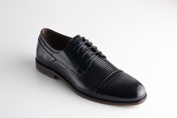 brown man's leather shoe with shoelaces on white background