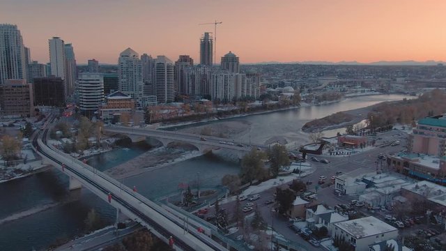 Aerial: Establishing shot of the Calgary city skyline and Bow River at sunset. 
