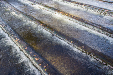 Water pours down the stairs in the river. Cascading waterfall. System for stopping the flow of water.