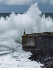 Fototapeta na wymiar Shocking wave hitting the breakwater of Mutriku, Spain, on the Basque coast