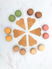 Fun flat lay composition of the colorful and sweet tasting small French cake macaron or macaroon combined with cookies