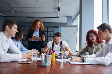 Young caucasian team of business partners coworking in office together, gathered to discuss. Professional occupation concept