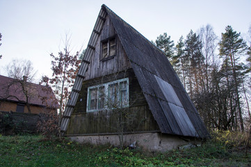 An old abandoned house in the shape of a triangle hut.