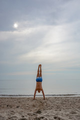 a man on the beach doing handstand