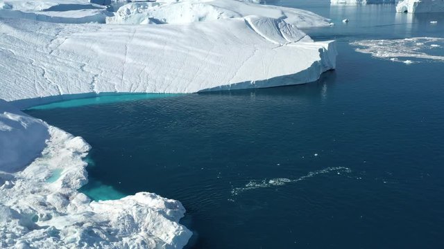4K Aerial Drone shot of Iceberg and ice from glacier in arctic nature landscape on Greenland. Aerial video drone footage of icebergs in Ilulissat icefjord. Affected by climate change and global warmin