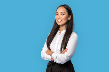 Freestyle. Young woman wearing shirt and skirt standing isolated on blue crossed arms posing confident