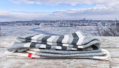 Two pairs of wool socks on a wooden table against winter background