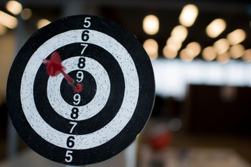 Red dart hit the target on bulls eye on blurry background 