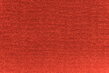 Red artificial carpet texture close-up, top view