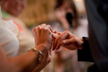 Obraz premium An unrecognizable bride and groom exchanging of the Wedding Rings in church during the christian wedding ceremony 