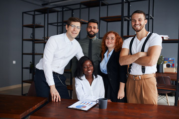 Cheerful multiracial team of male and female professionals posing in the office, career driven and successful corporate employees smiling and enjoying their work. Business and development.