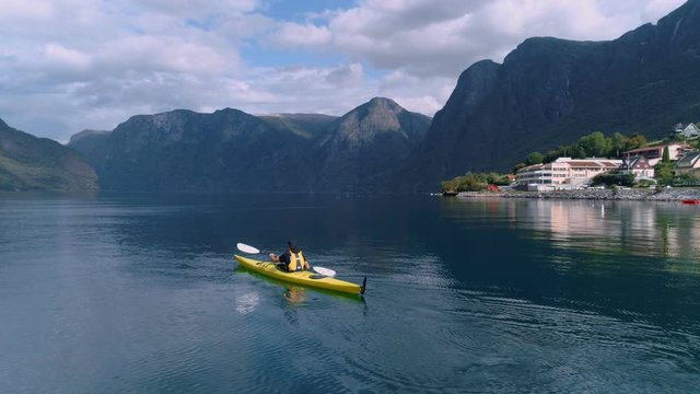 Aerial drone shot of yellow kayak in fjord water