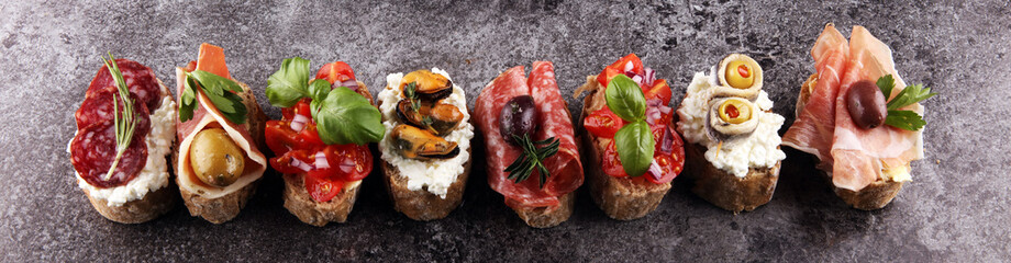 Appetizers table with italian antipasti snacks and wine in glasses. Brushetta or authentic...