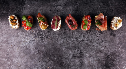 Appetizers table with italian antipasti snacks and wine in glasses. Brushetta or authentic traditional spanish tapas set, cheese variety