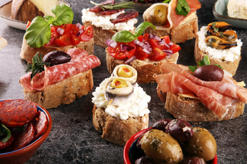 Appetizers table with italian antipasti snacks and wine in glasses. Brushetta or authentic traditional spanish tapas set, cheese variety