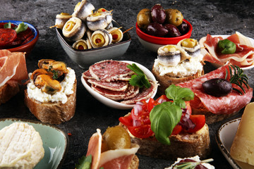 Appetizers table with italian antipasti snacks and wine in glasses. Brushetta or authentic traditional spanish tapas set, cheese variety