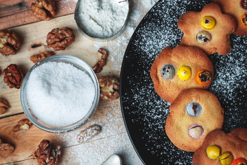 Still life making homemade cookies for Christmas with cookies, black plate, flour, egg, nuts, chocolate, grater, stick spoon, vanilla, cinnamon and molds. Top view without people