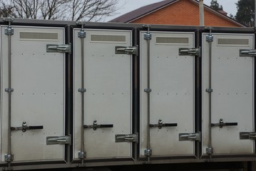 row of gray closed doors on a street truck refrigerator
