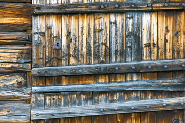 Old weathered and rustic door into abandoned building outdoors in the norwegian mountains. Texture and pattern concept.