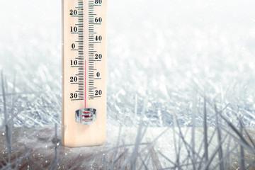 The wooden thermometer on the table with the low temperature at winter