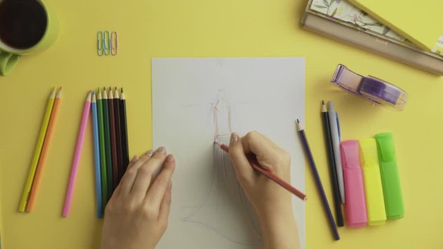 Top view of fashion designer use colour pencils to drawing dress sketch