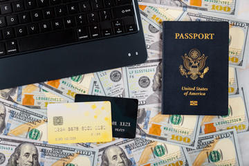 Technology and internet computer keyboard, hundred US dollar bills on buying a ticket online with credit card on American passport