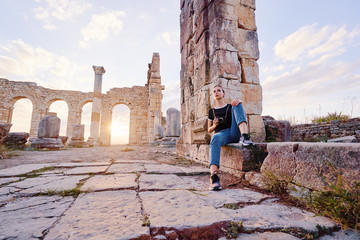 Tourism and hobby. Happy young woman taking photo of ancient antique city Volubilis. Traveling by Morocco. © luengo_ua