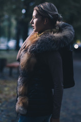 Fototapeta na wymiar Beautiful caucasian girl in winter clothes on the street, illuminated with a dark strong backlight she looks sensual and mysterious