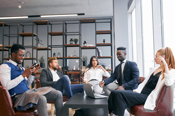 Internatonal group of business partners discuss future successful deal in modern office, wearing formal wear - obrazy, fototapety, plakaty