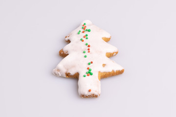 Christmas Ginger and Honey cookie. Gingerbread cookie in tree shape isolated on white background.
