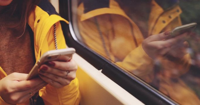 Young Woman Hands Using Smartphone on a Train. SLOW MOTION 4K. Unrecognizable Girl using cell phone during her daily commute. Social network, planning, communicating.