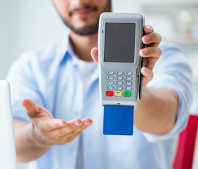 Man processing credit card transaction with POS terminal