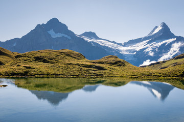 Naklejka na ściany i meble Lake Bachalpsee with snow covered mountain peaks in Bernese Alps, Switzerland
