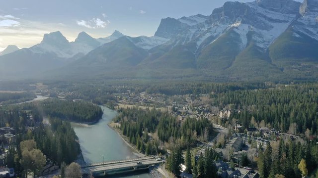 Aerial flying over the town of Canmore and Bow River near Banff. The town is surrounded by the Canadian Rocky Mountains. Alberta, Canada. 