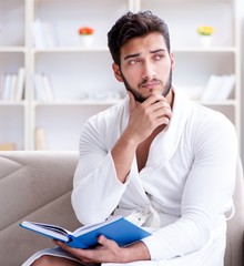 Young man student businessman reading a book studying working at