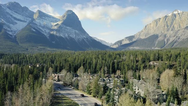 Aerial flying over the town of Canmore and Bow River near Banff. The town is surrounded by the Canadian Rocky Mountains. Alberta, Canada. 