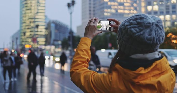 Young Woman Using Smartphone in the City, Taking Pictures. SLOW MOTION 4K. Girl using cell phone photography app, traffic lights background. 