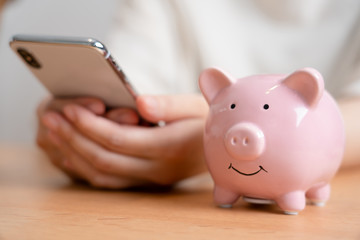 豚の貯金箱とスマートフォン