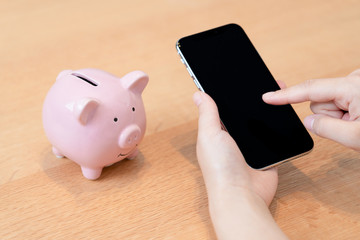豚の貯金箱とスマートフォン