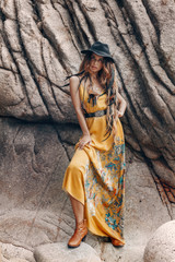cheerful beautiful young boho style model on the stone beach