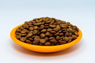 Roasted coffee beans in a bowl isolated on white background