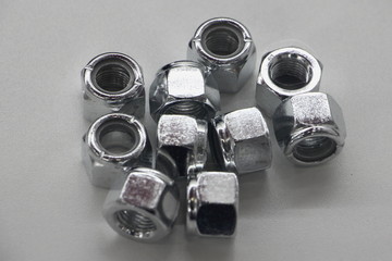 Chrome new nuts with fixation ring on white background close up