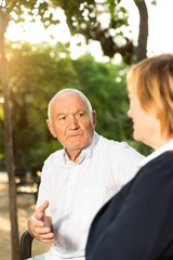 Elderly couple talking on bench