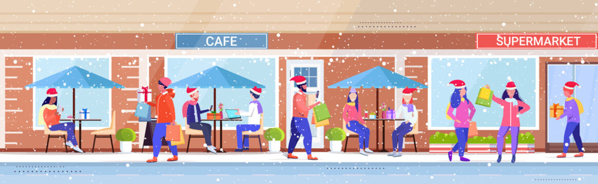 people in santa hats walking outdoor mix race men women holding colorful shopping bags christmas sale winter holidays concept modern city street building exterior horizontal full length vector