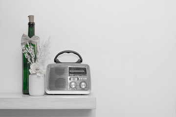 radio, flower and green bottle on white background