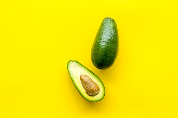 Avocado - ripe and bright, cutted in half - on yellow background top view copy space