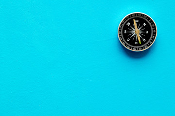 Compass - small and stylish - on blue background top view copy space