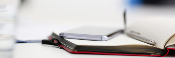 Silver pen lying on opened notebook sheet closeup