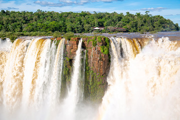 View to Devil`s Throat and Salto Union with rainforest, blue sky, white clouds and small rainbow, Iguazu Falls, Argentina